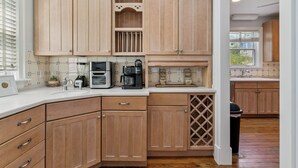 Una cocina con armarios de madera, un lavamanos, un microondas y una cafetera.