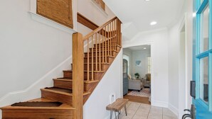 Una escalera de madera con barandilla que conduce a un rellano con un banco.