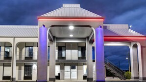 A gas station with a covered fuel pump area, multiple service bays, and a staircase leading to the upper level. - Studio 6 Meridian, MS - Bonita Lakes (Meridian)