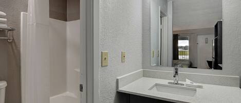 Un baño moderno con una bañera, un lavabo y un espejo.