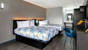 A hotel room with two beds, a desk, a chair, and a TV. - Studio 6 Meridian, MS - Bonita Lakes (Meridian)