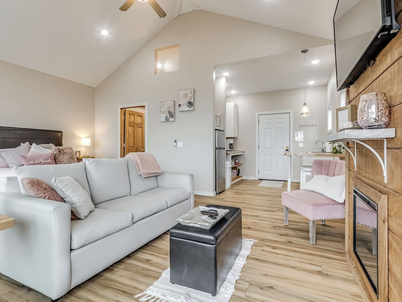 Een moderne woonkamer met een bank, een voetenbankje en een televisie.
