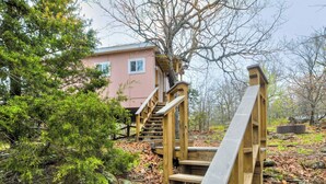 A wooden staircase leading to a building surrounded by trees and foliage. - Enchanting Memory Maker-Treetop Hideaway-Jacuzzi (Stigler)