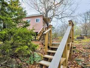 A wooden staircase leading to a building surrounded by trees and foliage. - Enchanting Memory Maker-Treetop Hideaway-Jacuzzi (Stigler)