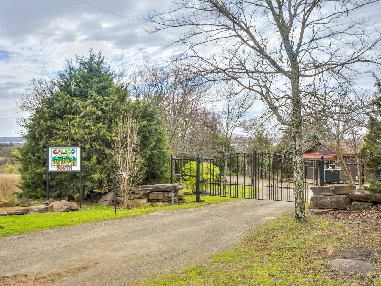 A gated entrance to a property with a sign indicating 'CALIGO THE HILLS SOUTH'.