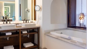 A modern bathroom with two sinks, a large mirror, a vanity with shelves, and a bathtub. - Beachfront Golf & Spa Paradise at Casa Del Mar (San Jose del Cabo)