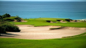 A golf course with bunkers and a view of the ocean. - Beachfront Golf & Spa Paradise at Casa Del Mar (San Jose del Cabo)