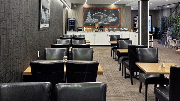 A modern restaurant with a bar area, black leather chairs, and a patterned wall. - Big Bird Inn Wawa, SureStay Collection by Best Western (Wawa)