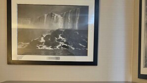 A fireplace with a framed photograph above it. - Big Bird Inn Wawa, SureStay Collection by Best Western (Wawa)