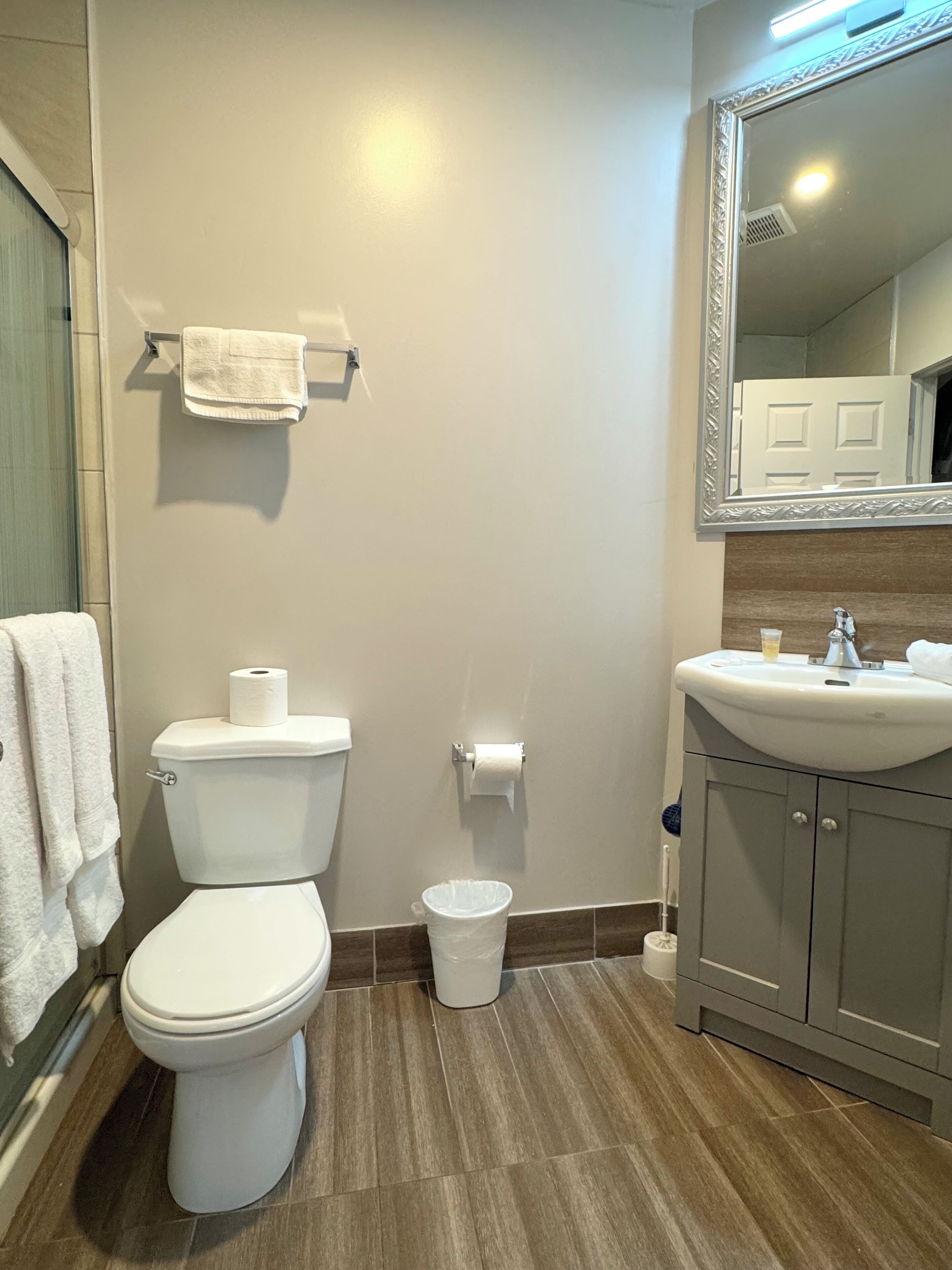 Un baño con inodoro, lavamanos y espejo.