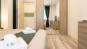 A hotel room with a bed, a mirror, a wardrobe, and a small desk with a chair. - Green Pearl ☆☆☆☆☆ - Apartment 100 meters from the lake - WiFi - By Guestaly (Arona)