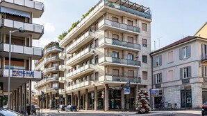 A multi-story building with balconies, a sign for 'REALE MUTU,' and a Christmas tree. - Green Pearl ☆☆☆☆☆ - Apartment 100 meters from the lake - WiFi - By Guestaly (Arona)