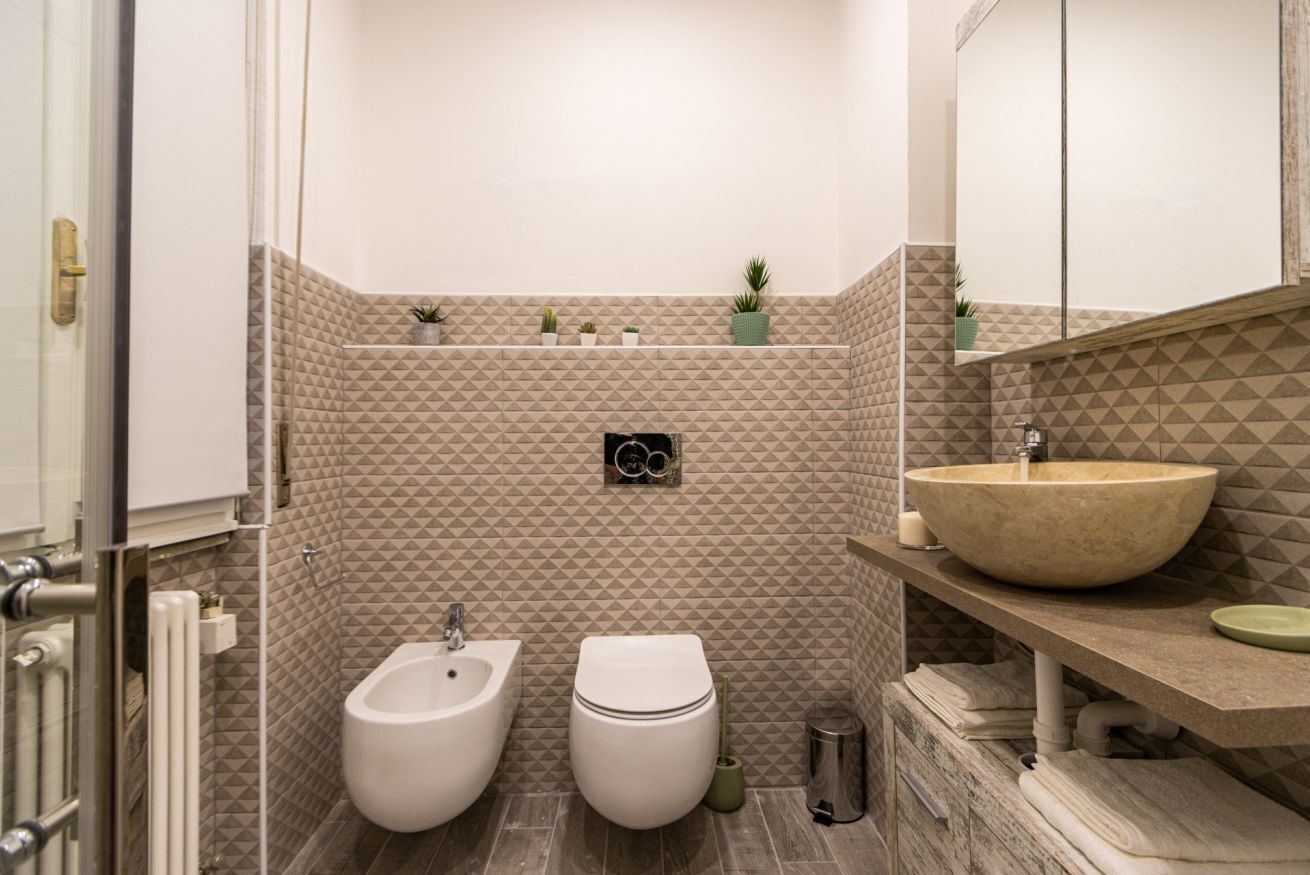 Ein Badezimmer mit Bidet, Toilette, Waschbecken und Handtuchhalter.