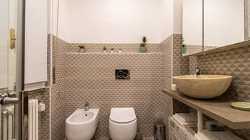 Ein Badezimmer mit Bidet, Toilette, Waschbecken und Handtuchhalter.