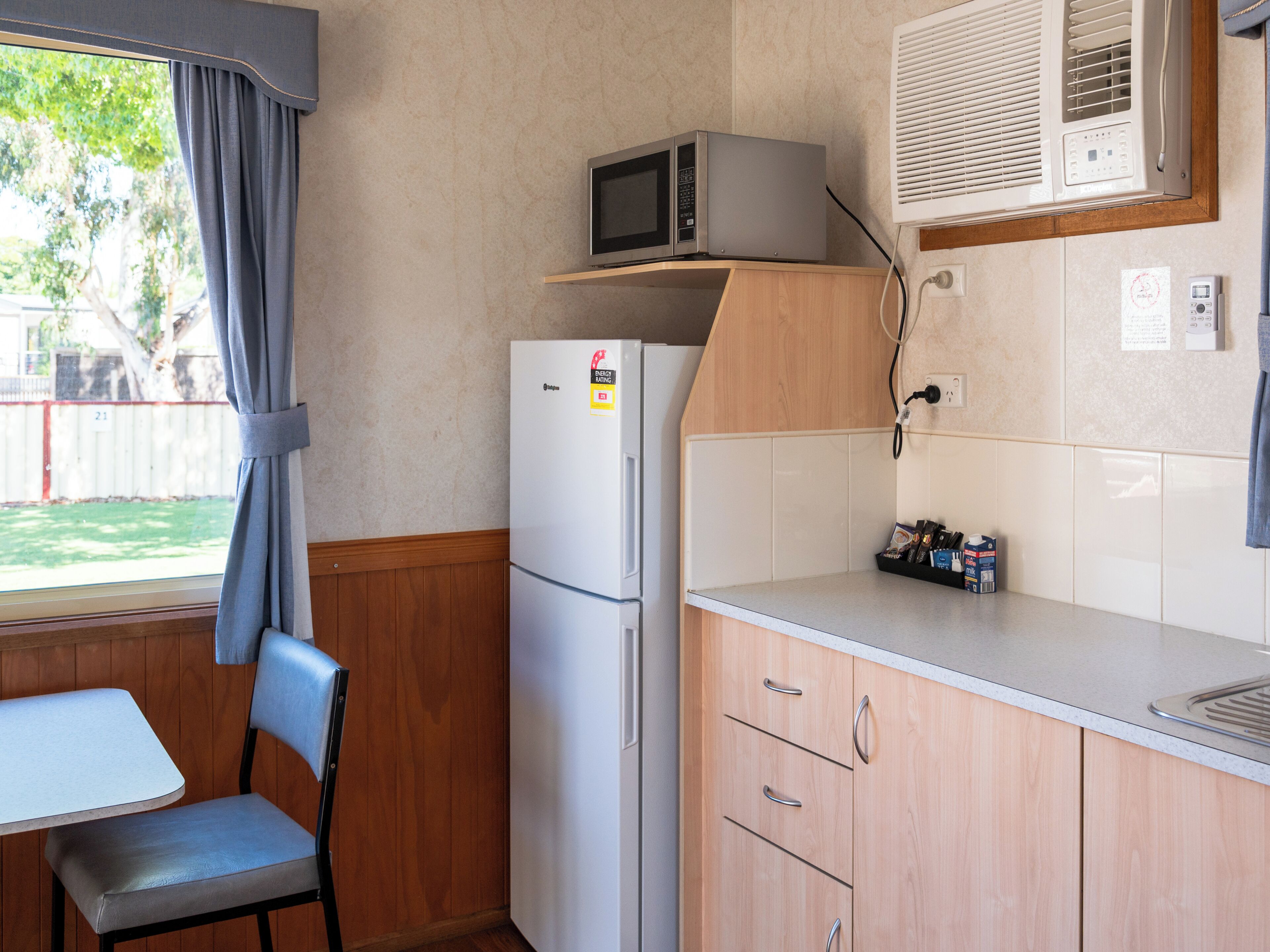 A compact kitchenette with a refrigerator, microwave, and a small countertop.