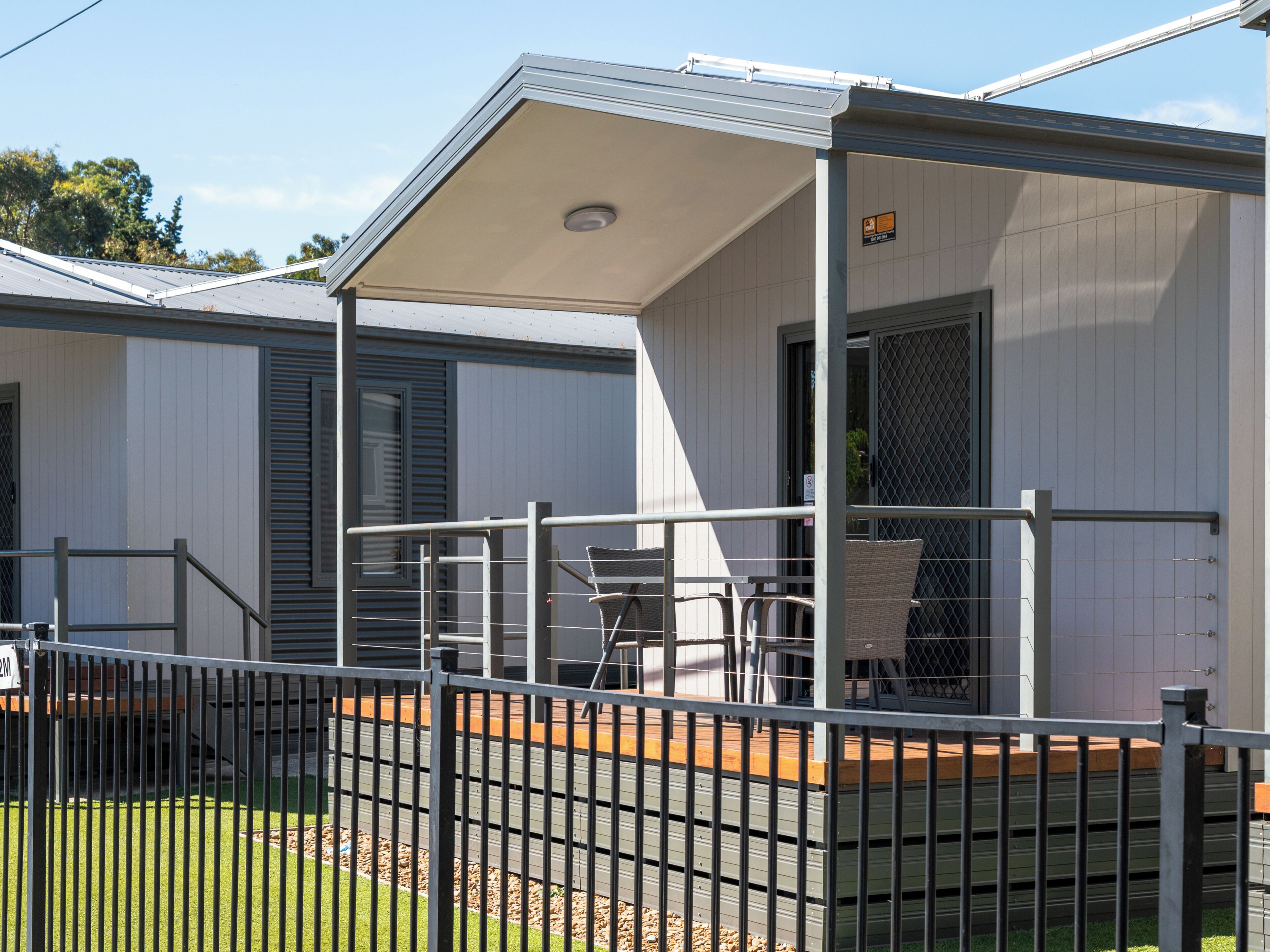 A single-story building with a covered porch and a fenced outdoor area.