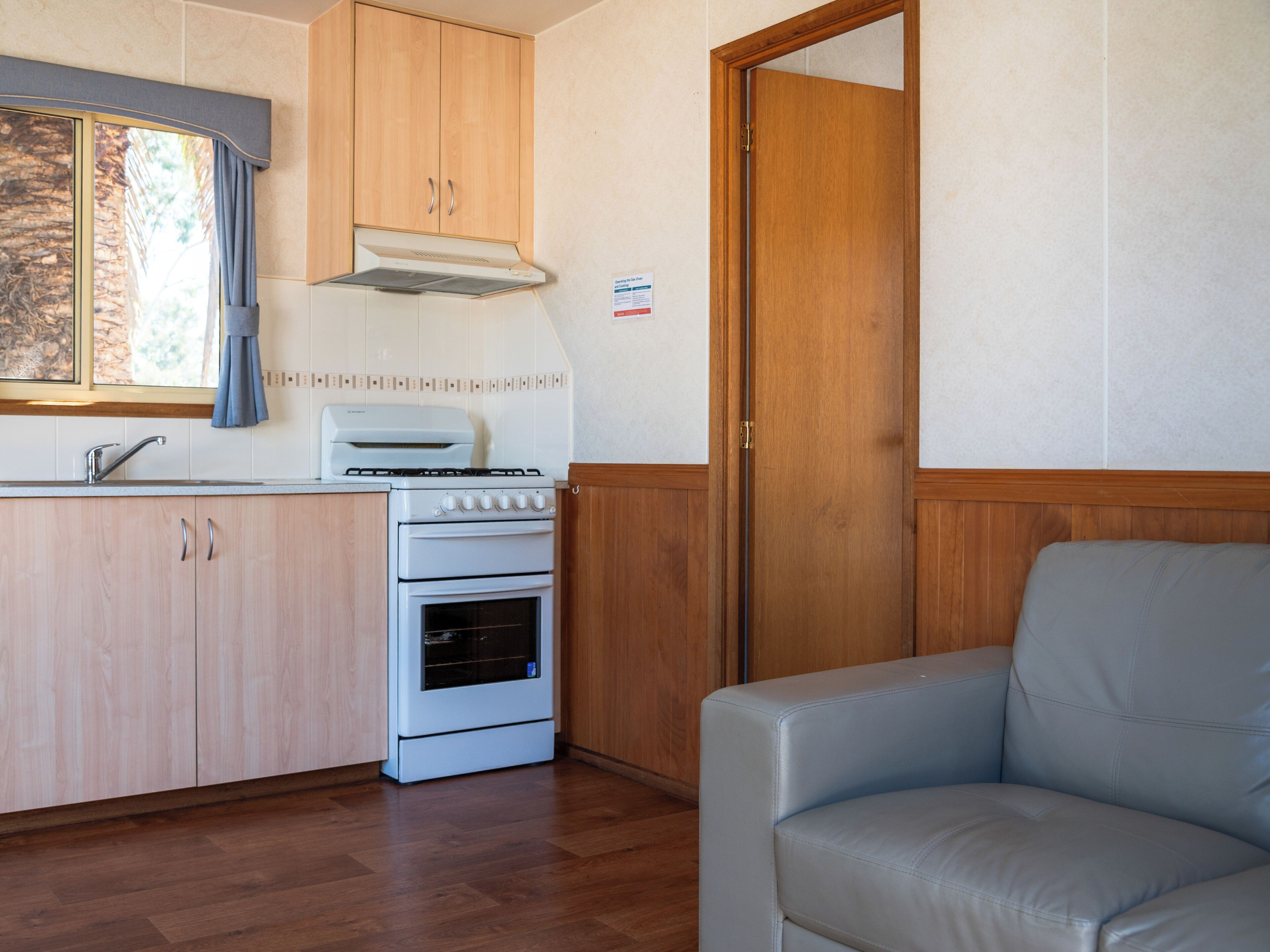 A compact kitchenette with a stove, oven, and sink.