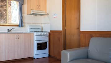 A compact kitchenette with a stove, oven, and sink.