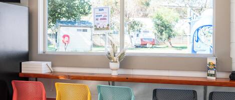 A seating area with colorful chairs and a window with a view of the outside.