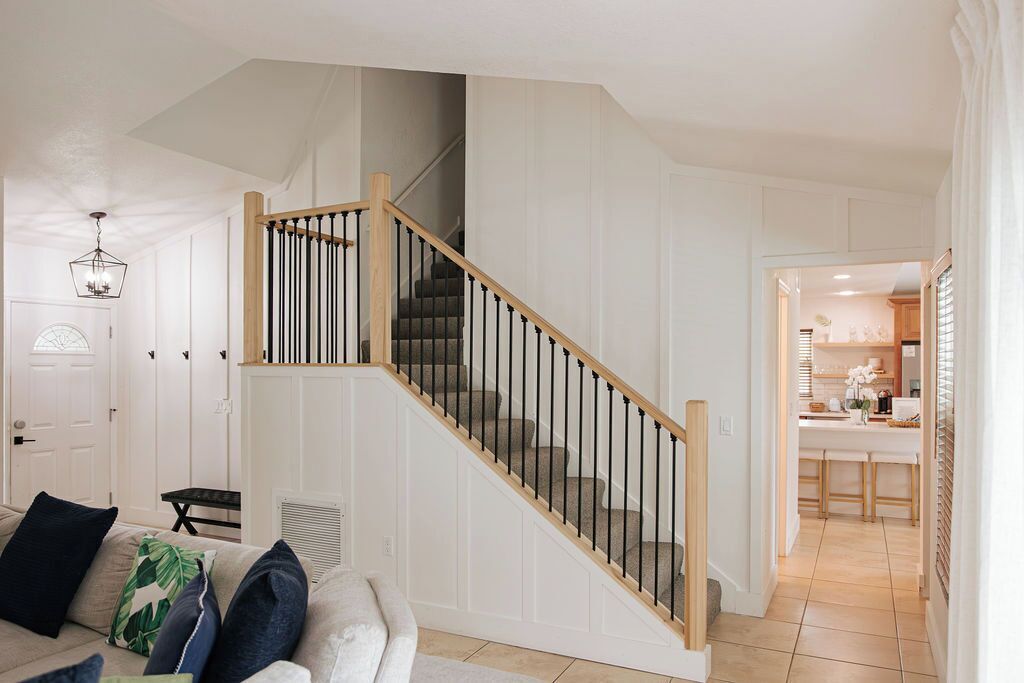 A staircase with wooden railings and black balusters leading to a second floor.
