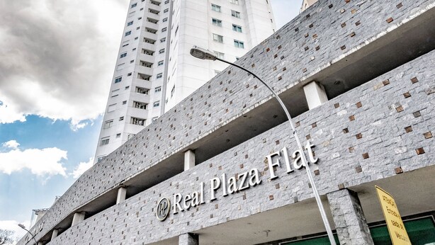 A building with a sign reading "Real Plaza Flat." - B.Living (Curitiba)