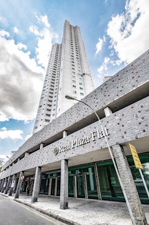 Un immeuble sur lequel on peut lire l’inscription : « Real Plaza Flat ».