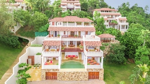 A multi-story hotel with a central courtyard, balconies, and lush greenery surrounding the property. - Cinnamon House by The Serendipity Collection (Weligama)