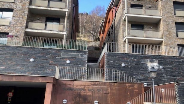 Um edifício de vários andares com uma escadaria que dá acesso a um nível inferior.