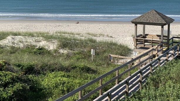 A beach with a wooden gazebo and a wooden walkway. - Shore Beats Work! Direct Oceanfront Atlantic Beach Paradise (Atlantic Beach)