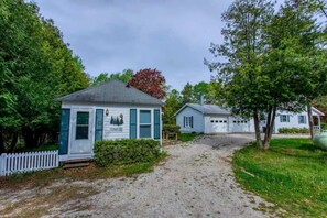 A gravel path leading to a small building with a white picket fence and a tree with red leaves. - Charming Studio in Door County – Private: Ephraim (Ephraim)