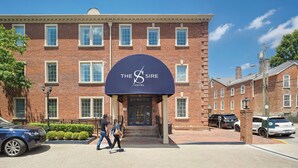 Un edificio de ladrillo con un cartel grande que dice 'The Sire Hotel' sobre la entrada.