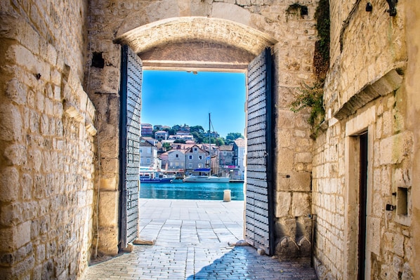 Stroll through a charming passageway to a picturesque harbor with views of the town across the water.