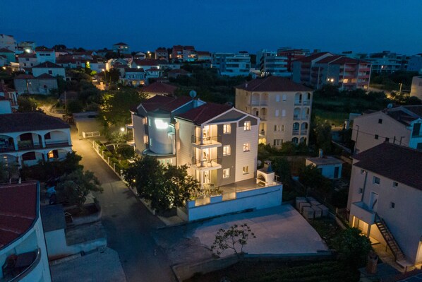A multi-story residential building with a central courtyard, surrounded by other houses.