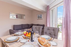 A dining area with a table set for four, including plates, glasses, and a bottle of wine.