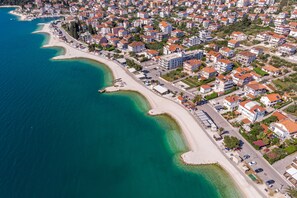 Overlooking a turquoise bay, this coastal area features a mix of houses and commercial establishments.