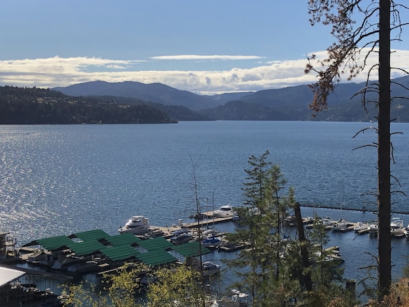 Uma marina com barcos atracados, cercada por montanhas e um céu claro.