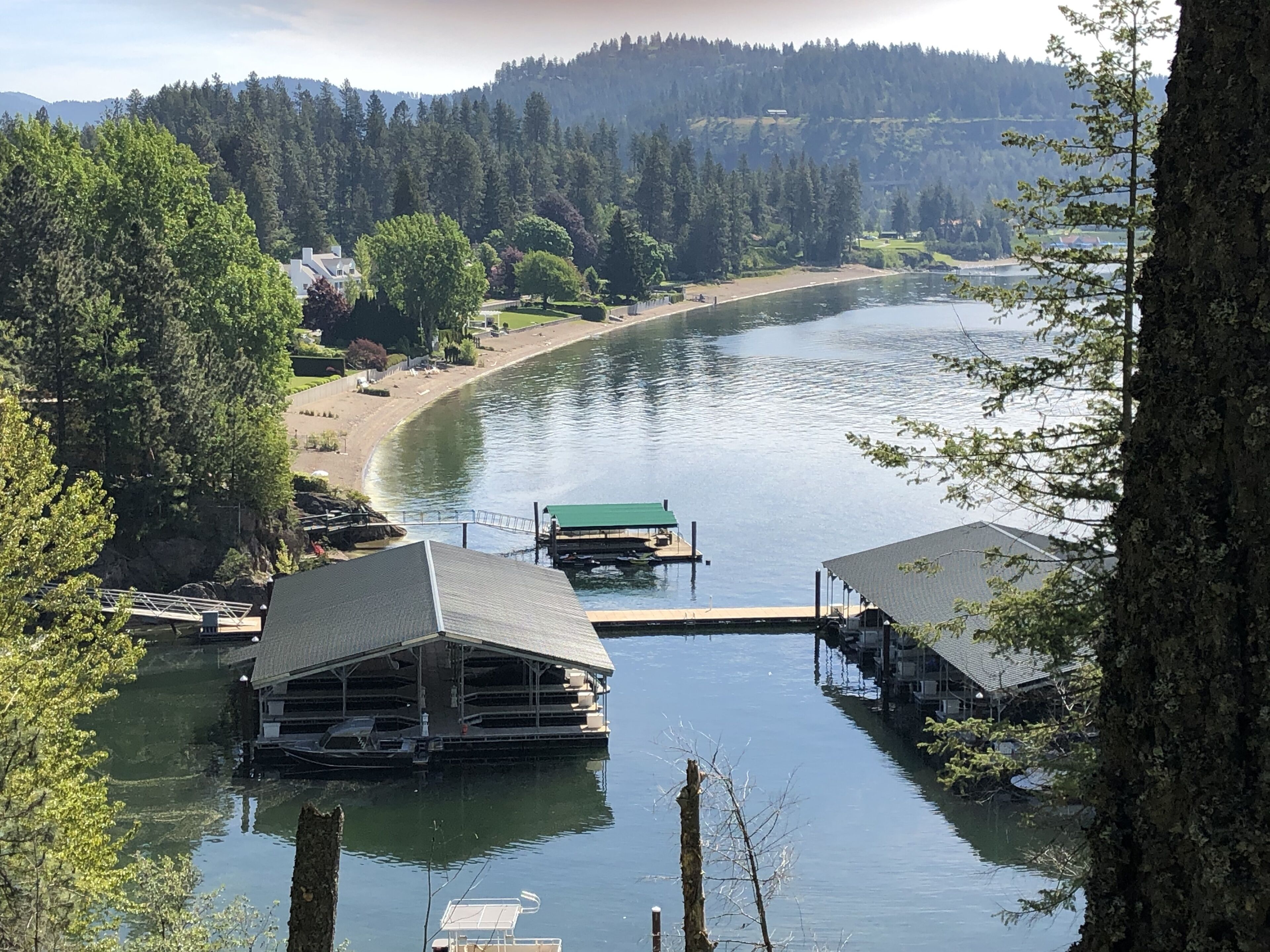 A lakeside property with docked boats, a covered boathouse, and a cabin.