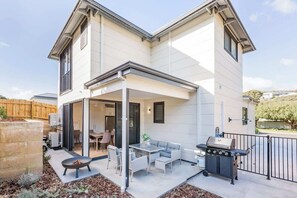 A two-story house with a covered patio area, a barbecue grill, and a dining set. - Yallingup Lagoon Beach House—A Spectacular Getaway (Yallingup)
