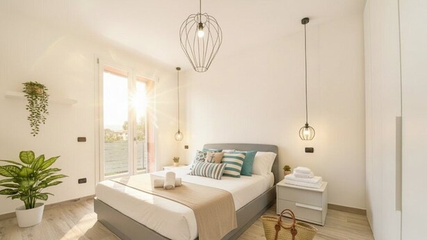 A modern bedroom with a large bed, bedside tables, a hanging light fixture, and a view through a sliding door. - Residenza Cantalupo – Relax Oasis with Poo l Ap38 (Imperia)