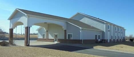 A two-story building with a covered entrance and a flat roof.