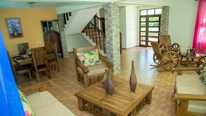 Un amplio espacio habitable con muebles de madera, una escalera y vistas al exterior.