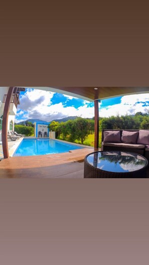 A swimming pool with a view of mountains and greenery, a lounge area with a sofa, and a small building labeled "Villa El Pescador 3". - Villa del Baiguate #3 (Jarabacoa)