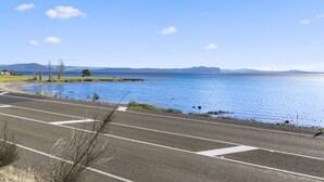 A coastal road with a clear view of the sea and distant mountains. - Waitetoko Waterfront - Waitetoko Holiday Home (Waitetoko)