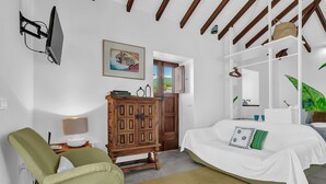 A bedroom with a bed, a wooden cabinet, a television, and a painting. - Tiled House with Sea & Mountain Views, Wi-Fi, Terrace, Garden, Pet-Friendly (La Orotava)
