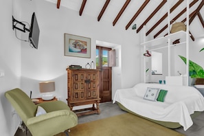 A bedroom with a bed, a wooden cabinet, a television, and a painting. - Tiled House with Sea & Mountain Views, Wi-Fi, Terrace, Garden, Pet-Friendly (La Orotava)
