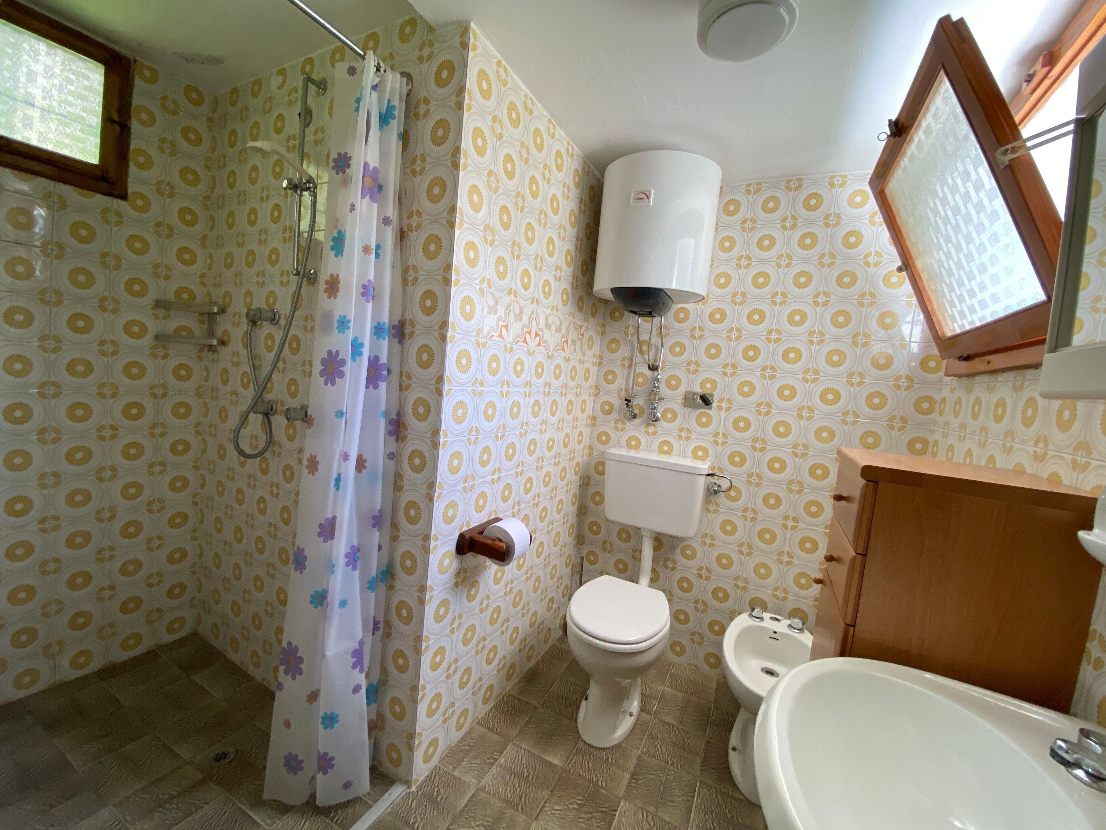 Une salle de bain équipée d’une douche, de toilettes, d’un bidet et d’une baignoire.