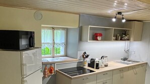 Une cuisine compacte équipée d’un four à micro-ondes, d’un évier et d’un petit plan de travail.
