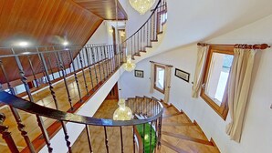 A multi-level interior with wooden floors, a spiral staircase, and chandeliers. - PREMIUM HABITAT CAN FERRER (Arenys de Munt)