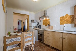 A kitchen with a microwave, toaster, coffee maker, and a sink.
