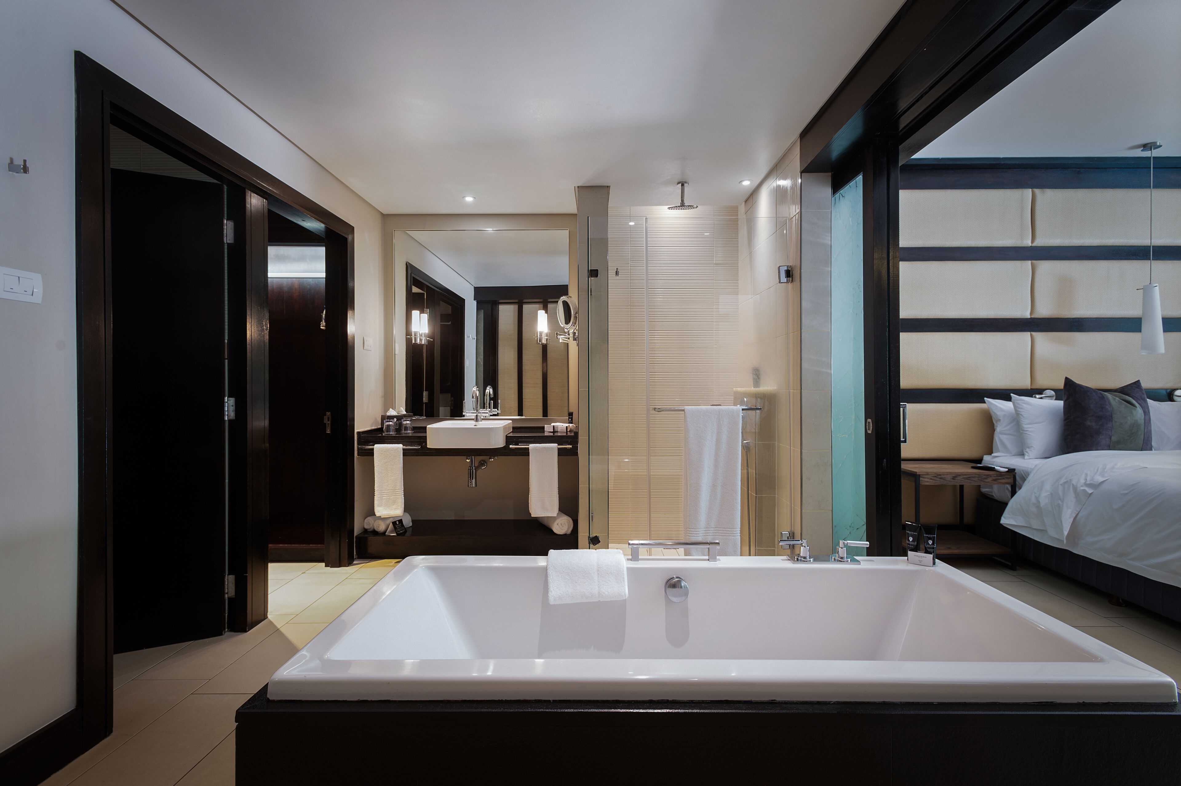 Un bagno moderno con una grande vasca, un mobile toilette con specchio e una zona doccia separata.